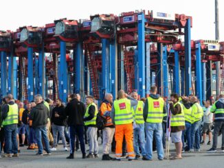 Hafenarbeiter protestieren vor dem Container Terminal.