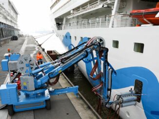 Ein Techniker justiert einen Kran der Landstromanlage in Hamburg-Altona.