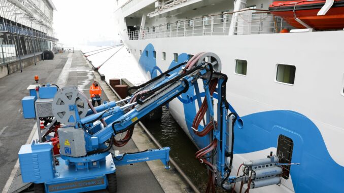 Ein Techniker justiert einen Kran der Landstromanlage in Hamburg-Altona.