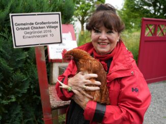 Angelika Regenstein hält die gerettetete Legehenne Marianne auf dem Arm.