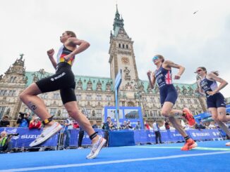 Triathlon-Teilnehmerinnen laufen am Hamburger Rathaus vorbei.