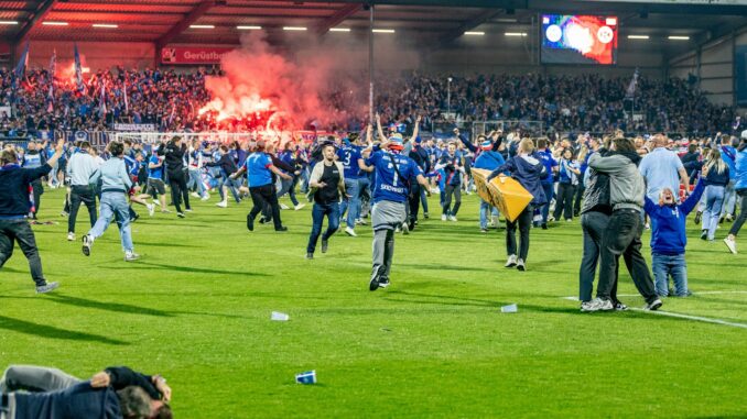 Pyro und der Platzsturm der Fans kommt Holstein Kiel teuer zu stehen.