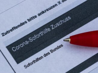 Ein Stift liegt auf einem Antrag für den Corona-Soforthilfe-Zuschuss.