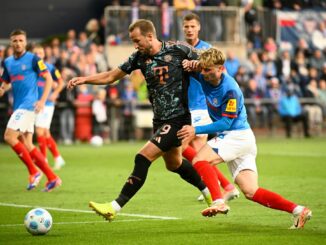 Bayerns Harry Kane (l-r) behauptet den Ball gegen Kiels Finn Porath.