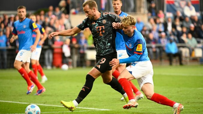 Bayerns Harry Kane (l-r) behauptet den Ball gegen Kiels Finn Porath.