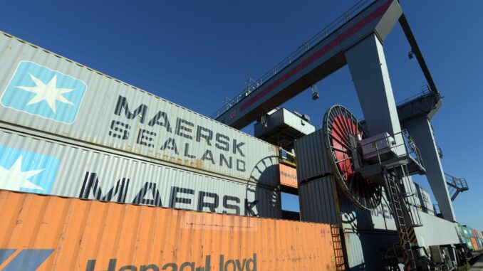 Container von Hapag-Lloyd und Maersk stehen in einem Umschlagbahnhof.