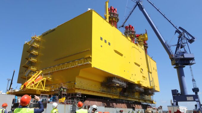 Auf einer Werft in Rostock schwimmt eine Offshore-Konverterplattform im Dock.