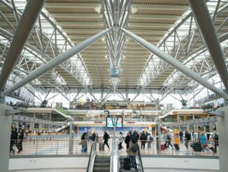 Fluggäste gehen durch die Abflughalle im Terminal 2 des Hamburger Flughafens.