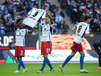 Gruß an Glatzel: Die HSV-Spieler Davie Selke (M) und Jean-Luc Dompe jubeln mit einem Trikot ihres verletzten Torjägers.