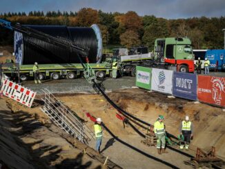 Das Erdkabel wird mit einem Schwertransporter geliefert und mit Hilfe einer Seilwinde in den Graben gehoben.