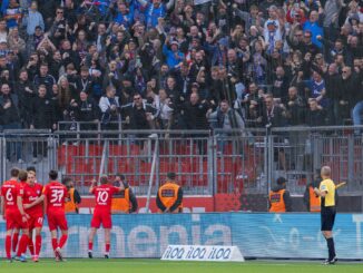 Die Spieler von Holstein Kiel freuen sich mit ihren Fans über einen unerwarteten Punkt bei Bayer Leverkusen.