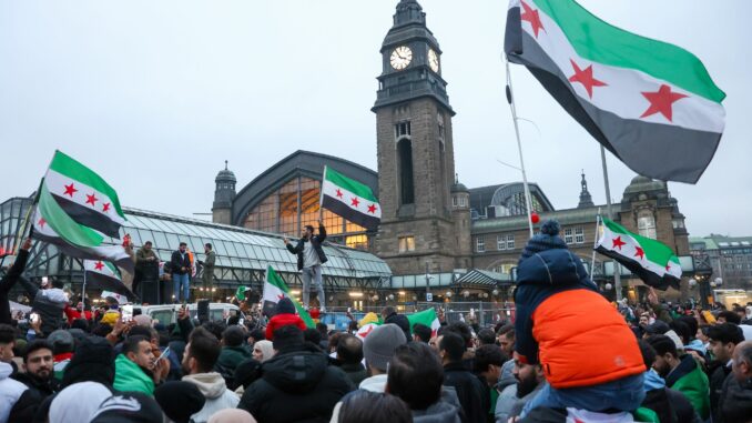 Vor dem Hamburger Hauptbahnhof herrscht bei einer Demonstration zum Sturz der syrischen Assad-Regierung ausgelassene Feierstimmung