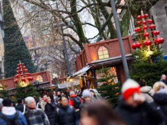 Passanten gehen mit Einkäufen durch die weihnachtliche Hamburger Innenstadt.