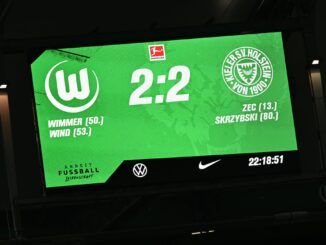 Bei der Partie zwischen Wolfsburg und Kiel in der Bundesliga kommt es zu einem Vorfall auf der Tribüne.