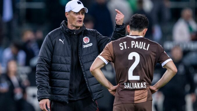 St. Paulis Manolis Saliakas (r) im Gespräch mit Trainer Alexander Blessin. Im Testspiel bei Eintracht Braunschweig erzielt der Abwehrspieler ein Eigentor. 