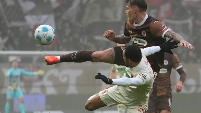  St. Paulis Eric Smith (r) und Augsburgs Alexis Claude-Maurice kämpfen um den Ball.