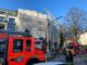 Über eine Drehleiter löschen Feuerwehrleute Glutnester auf dem Dach einer Baustelle ab.